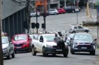 Homem é flagrado em cima de capô de carro em movimento no centro de Lafaiete